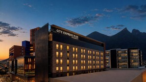 A modern hotel with a flat roof, multiple windows, and a sign reading 'CITY EXPRESS PLUS BY MARRIOTT.' - City Express Plus by Marriott Monterrey Nuevo Sur (Monterrey)