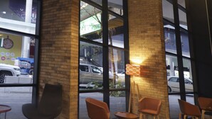 A modern interior with brick walls, large windows, and seating areas. - City Express Plus by Marriott Monterrey Nuevo Sur (Monterrey)