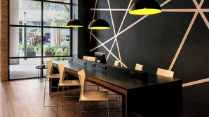 A modern bar area with a long counter, multiple chairs, and pendant lighting. - City Express Plus by Marriott Monterrey Nuevo Sur (Monterrey)