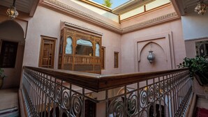 A courtyard with a wooden balcony, wrought iron railing, and a decorative lantern. - Riad Mazaya (Marrakech)