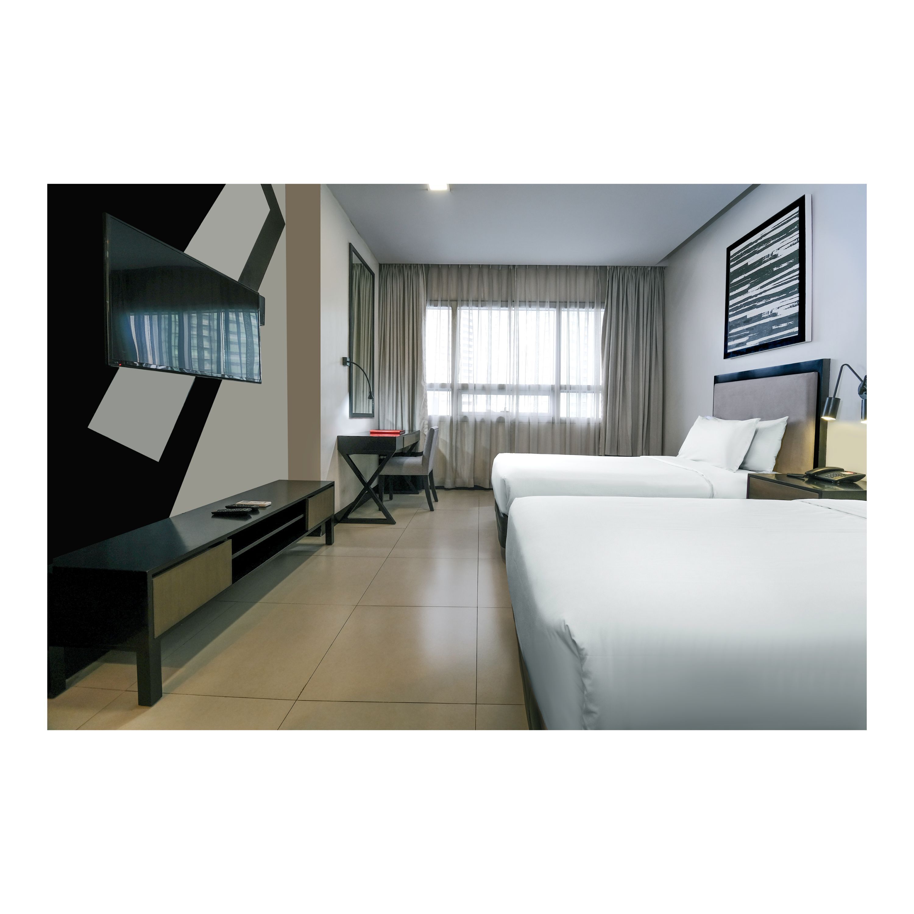 A hotel room with two beds, a desk, a chair, a TV, and a window with curtains.