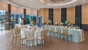 A banquet hall with round tables set for events, featuring gold chairs and white tablecloths. - Summit Hotel Magnolia (Quezon City)