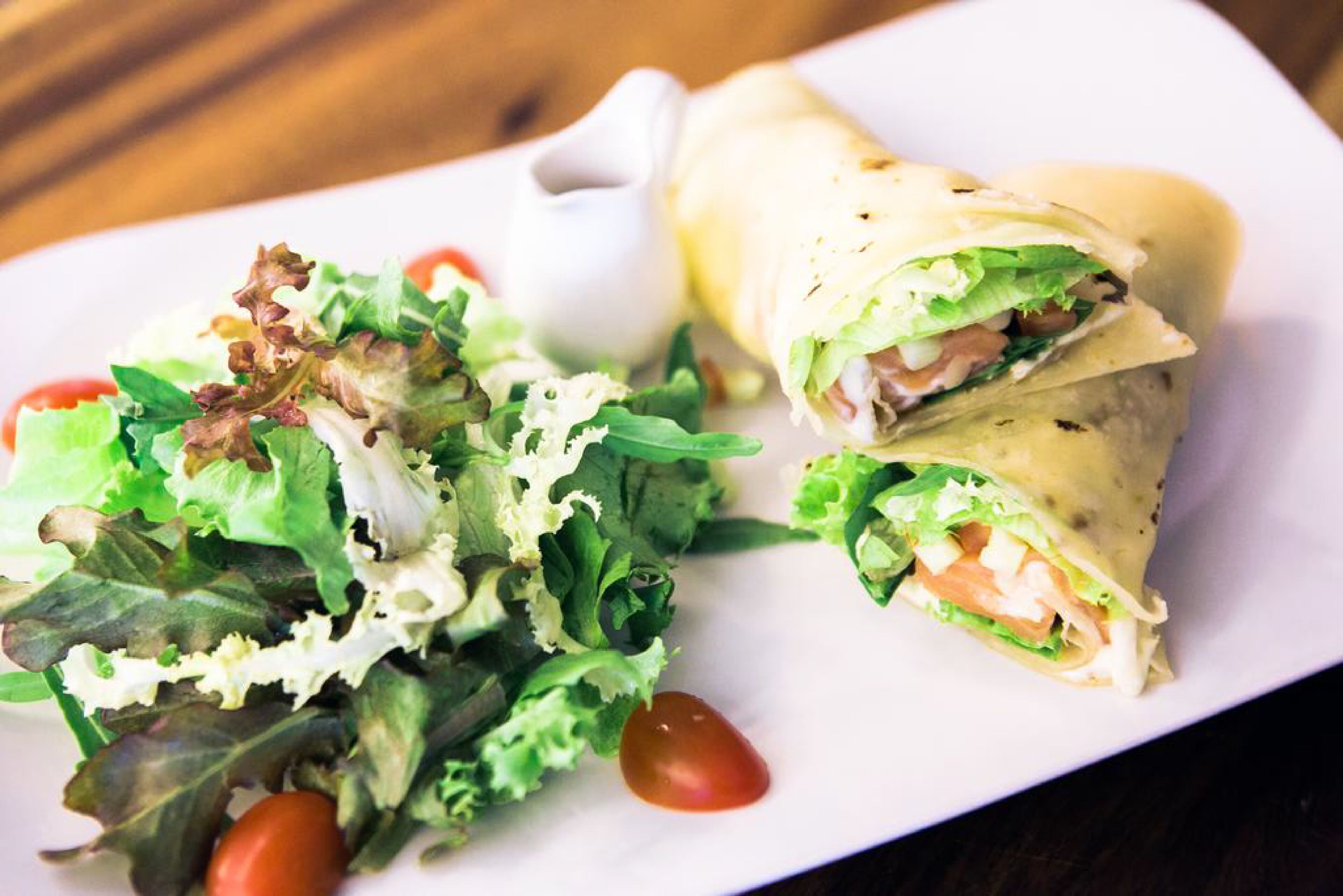 A plate with a wrap and a salad.