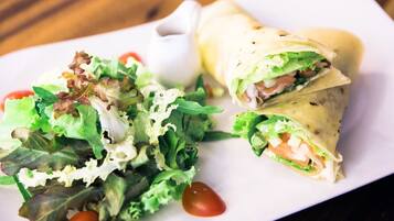 A plate with a wrap and a salad.