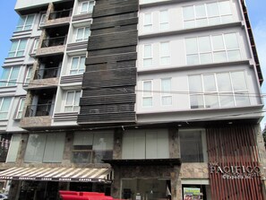 Un hôtel à plusieurs étages doté d’une façade moderne, caractérisée par un mélange de matériaux, notamment de la pierre et du verre.