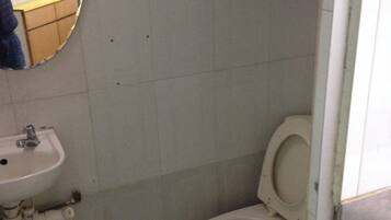 A small bathroom with a toilet, sink, and mirror.