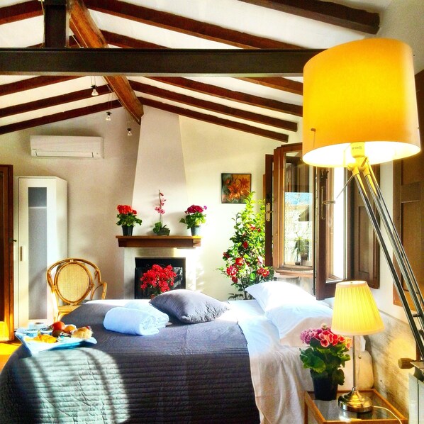 Une chambre à coucher avec un lit, une lampe de chevet et une fenêtre.