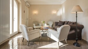 A living room with a sofa, two armchairs, a coffee table, and a floor lamp. - Villa degli Ulivi (Itri)