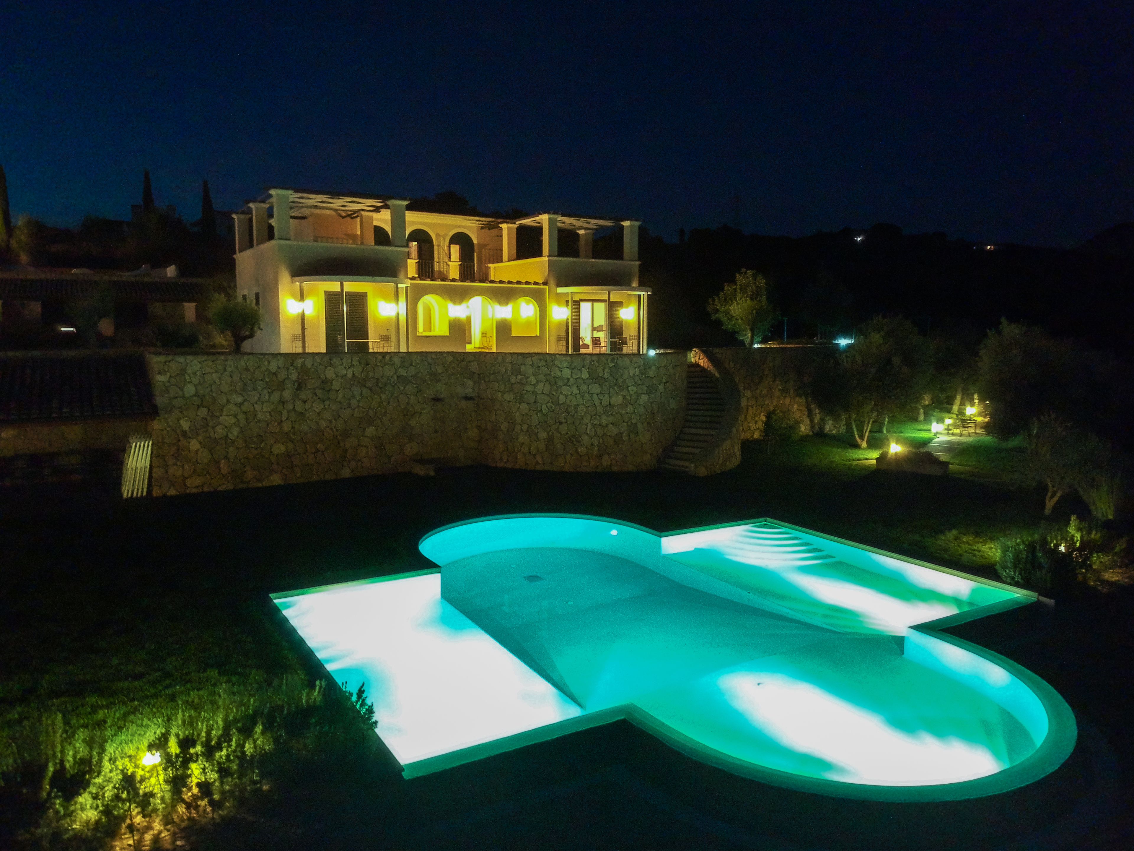 Una casa moderna con piscina, illuminata da luci interne, di notte.
