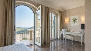 A hotel room with a large sliding glass door leading to a balcony with a scenic view. - Villa degli Ulivi (Itri)