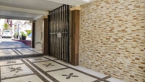 A hallway with patterned flooring, a metal gate, and a textured wall. - Capital O Hotel Dos Mares, Cabo San Lucas (Cabo San Lucas)