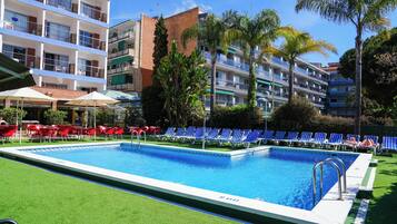 Een binnenzwembad, een buitenzwembad, parasols voor strand/zwembad
