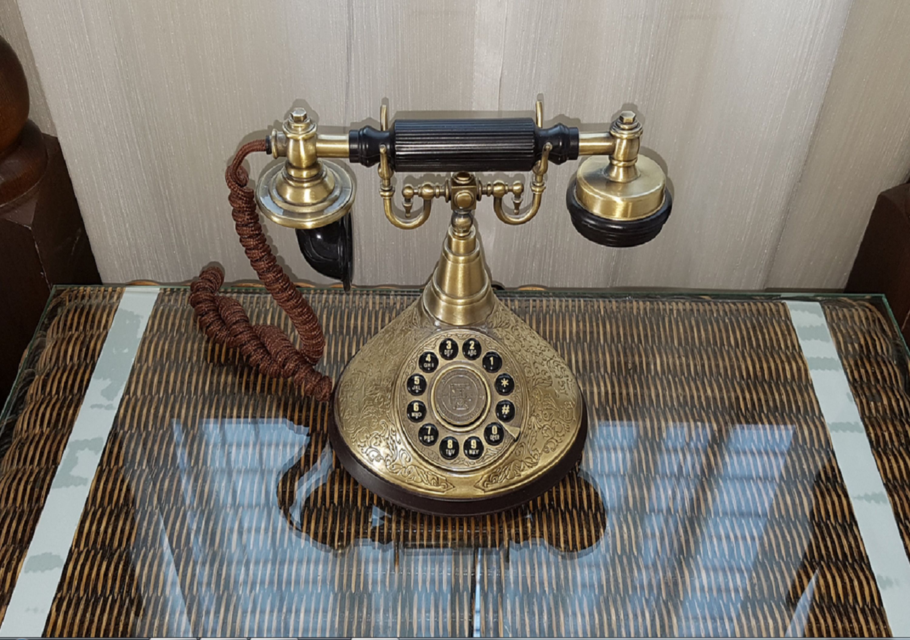 A vintage rotary dial telephone on a textured table.