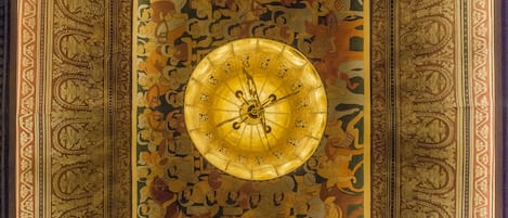 Un techo detallado y ricamente decorado con un diseño circular central y patrones intrincados.