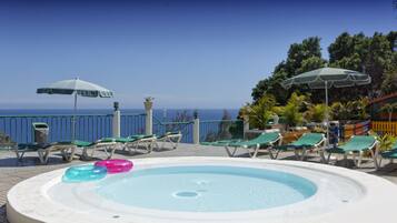 Een buitenzwembad, parasols voor strand/zwembad