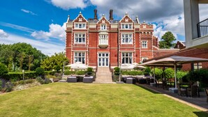 A large, red brick building with a symmetrical facade, a central entrance with steps, and a well-maintained lawn in front. - Wivenhoe House Hotel (Colchester)