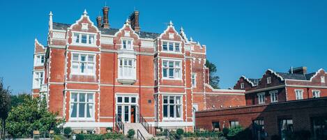 A large red brick building with multiple windows and a central entrance.