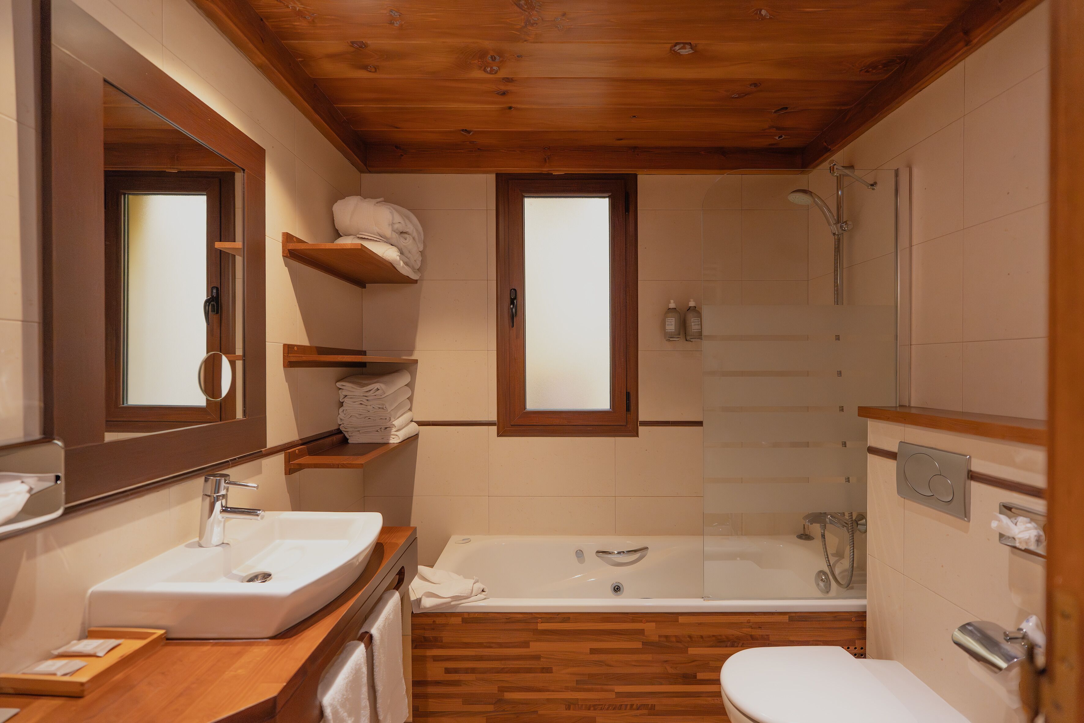 A bathroom with a wooden vanity, a bathtub, and a toilet.