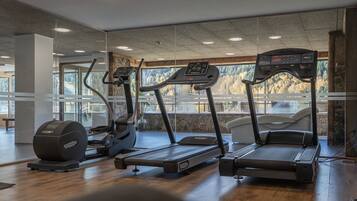 A gym with treadmills, a stationary bike, and a rowing machine.