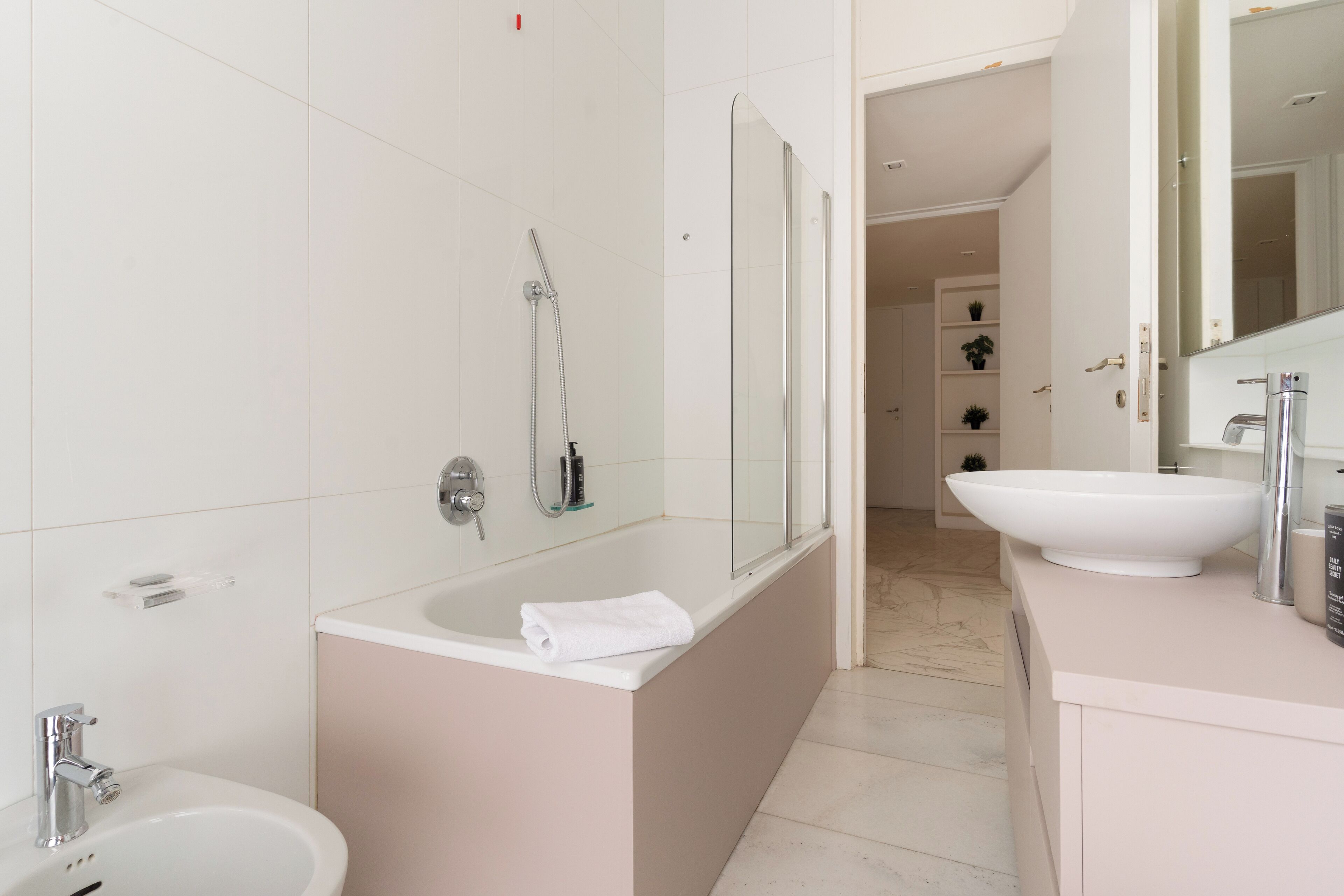 A modern bathroom with a bathtub, a sink, and a shower.