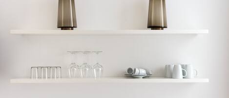Two white shelves with decorative vases and glassware.