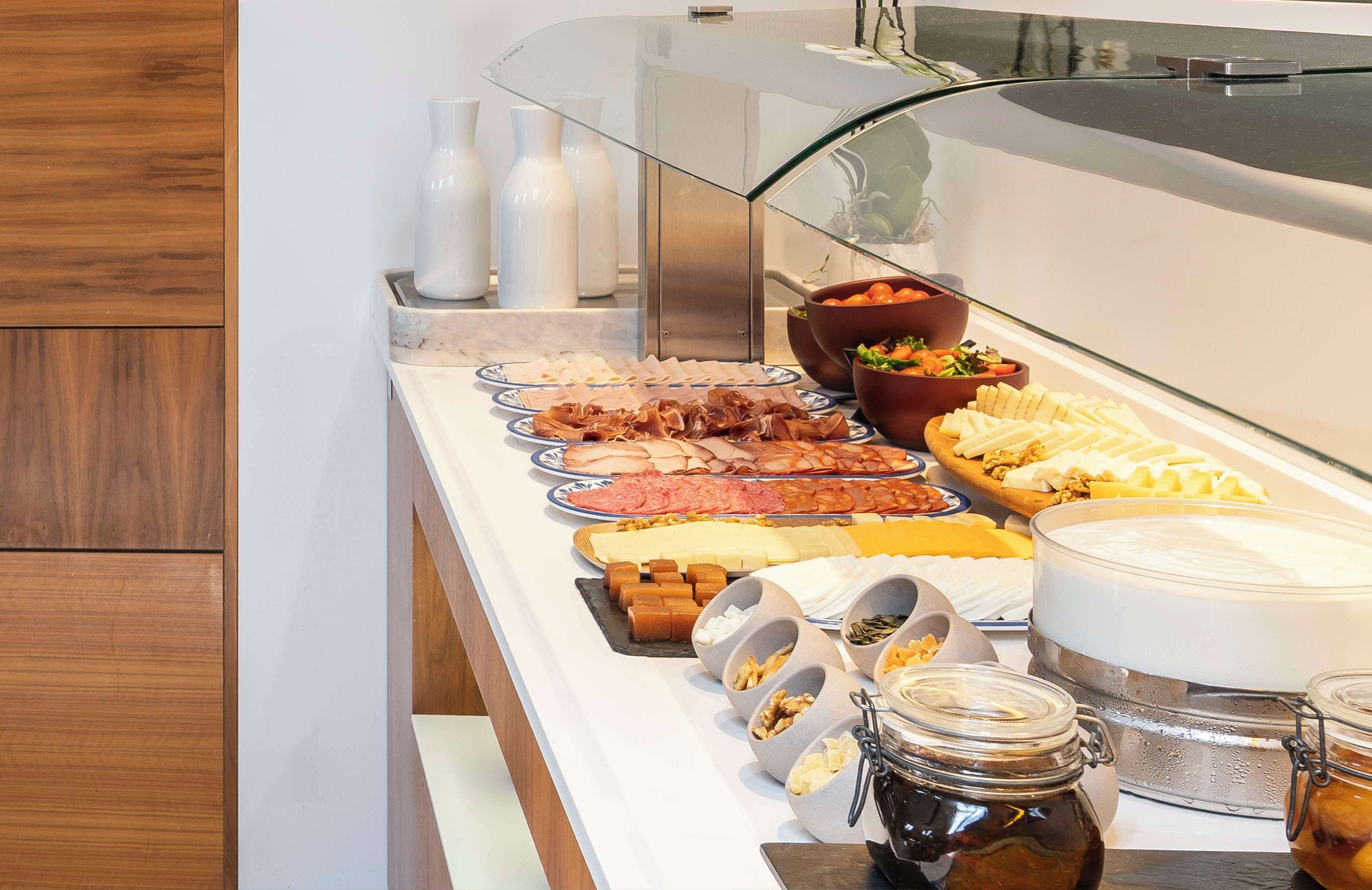 Un buffet proposant une variété de plats, notamment des viandes, des fromages et des fruits.