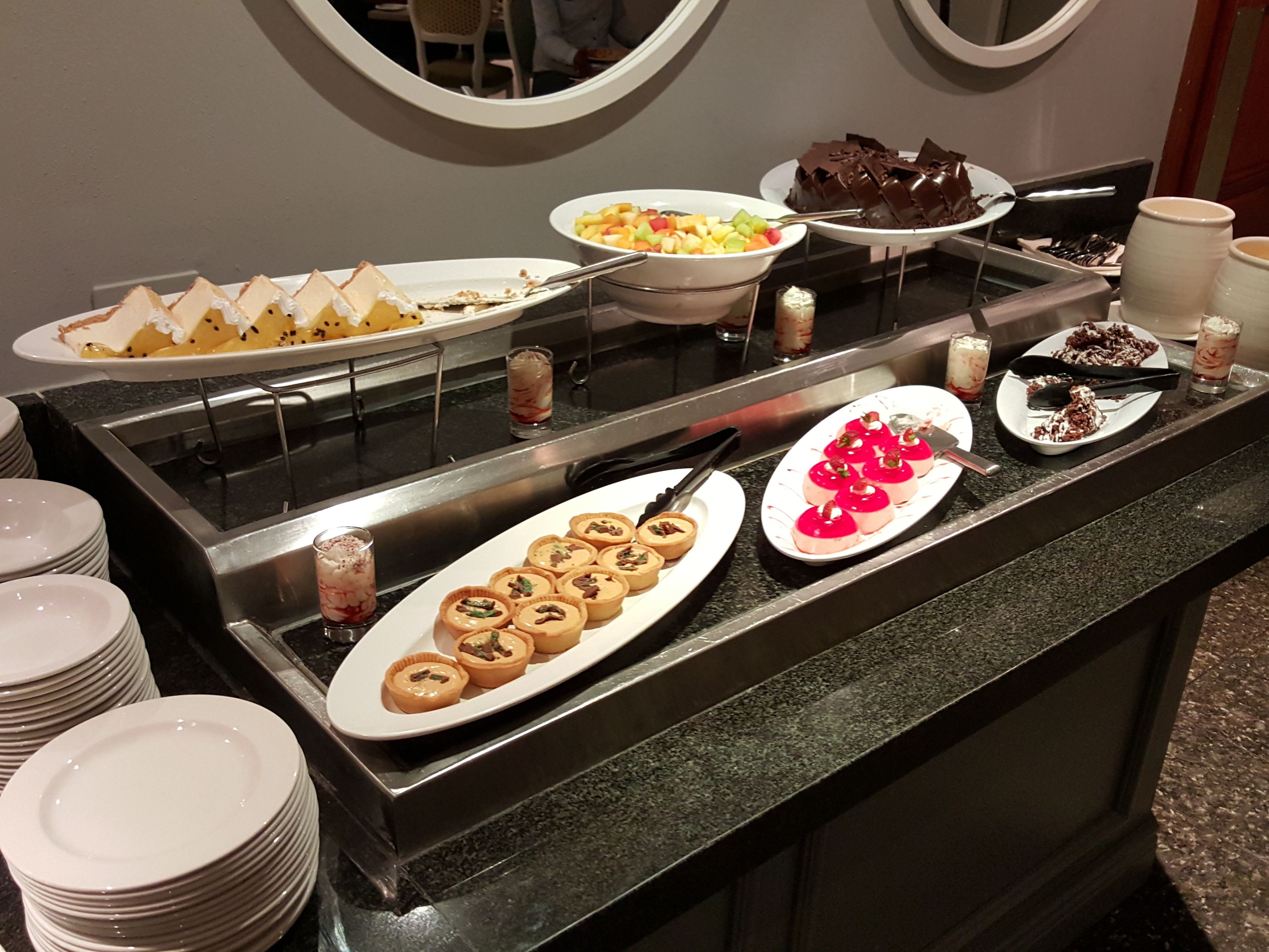 A buffet with various desserts and fruits.