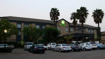 A Holiday Inn hotel with a parking lot filled with cars.