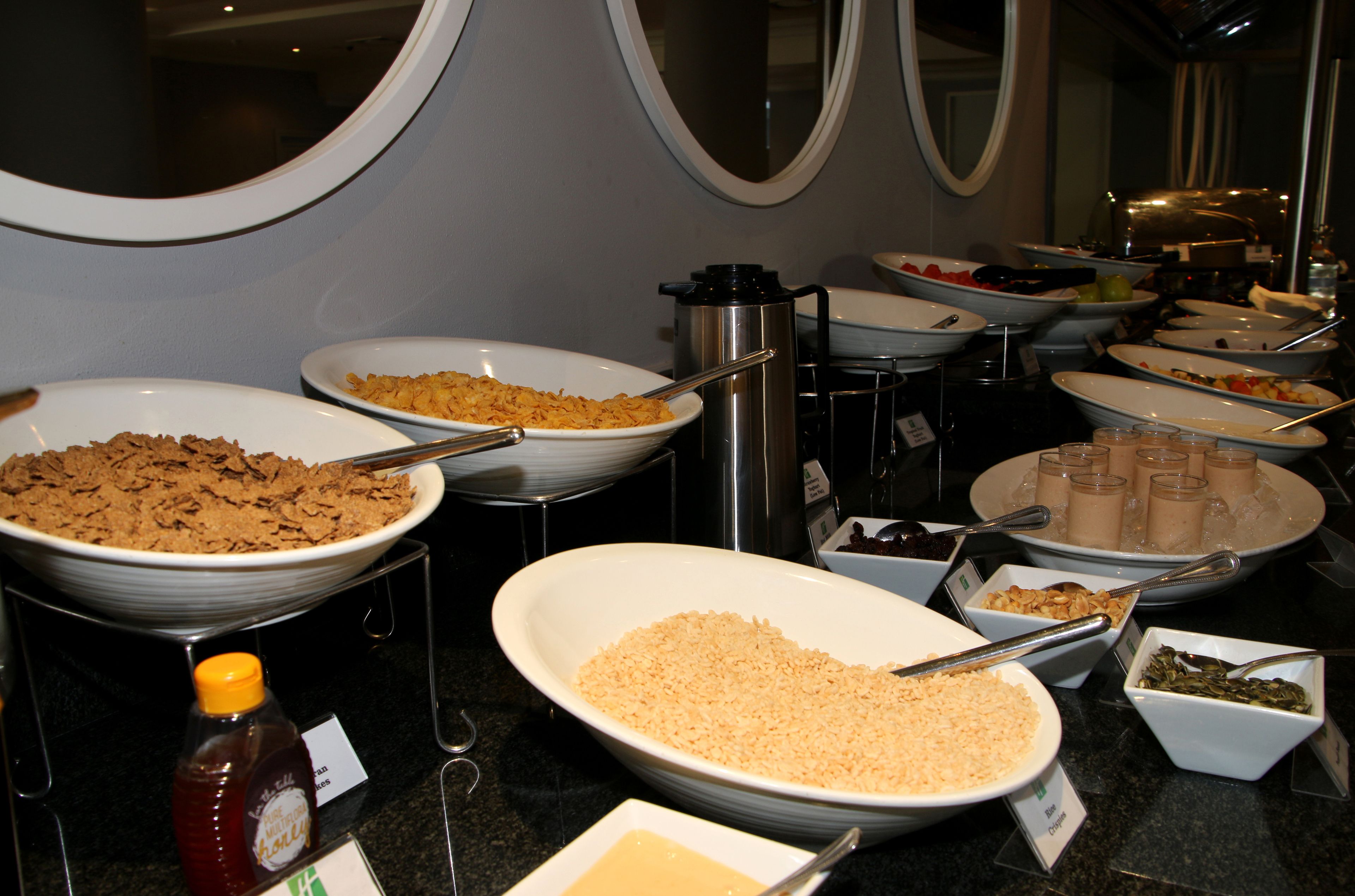 Un buffet proposant une variété de plats, notamment des céréales, du riz et des desserts.
