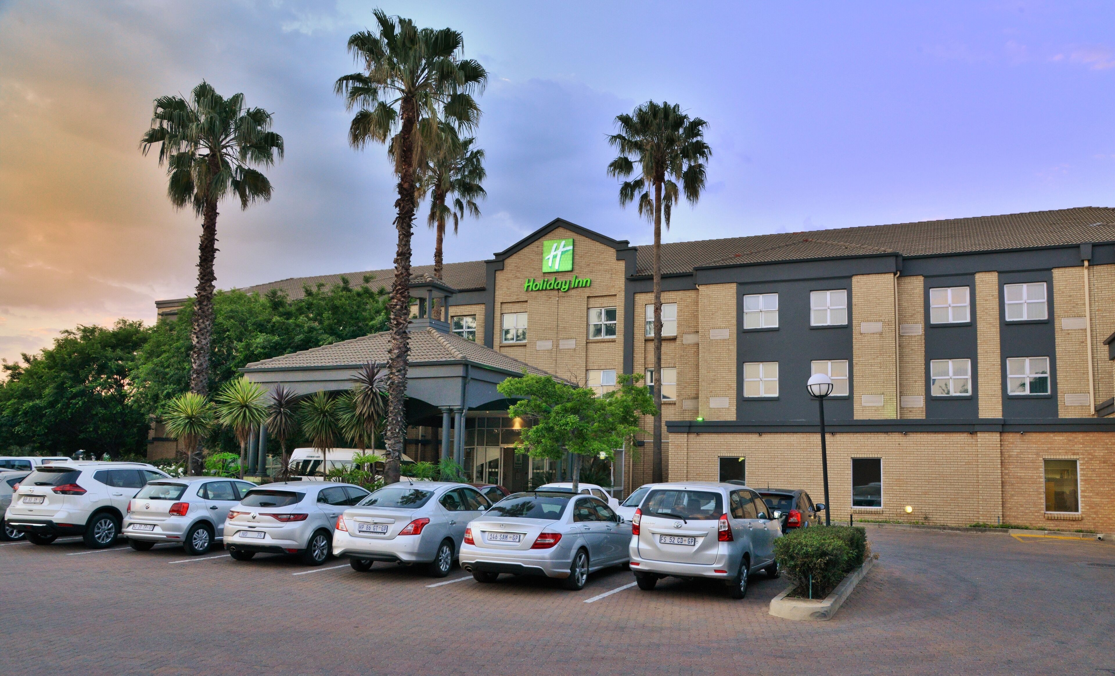 Un hôtel Holiday Inn avec un parking rempli de voitures.