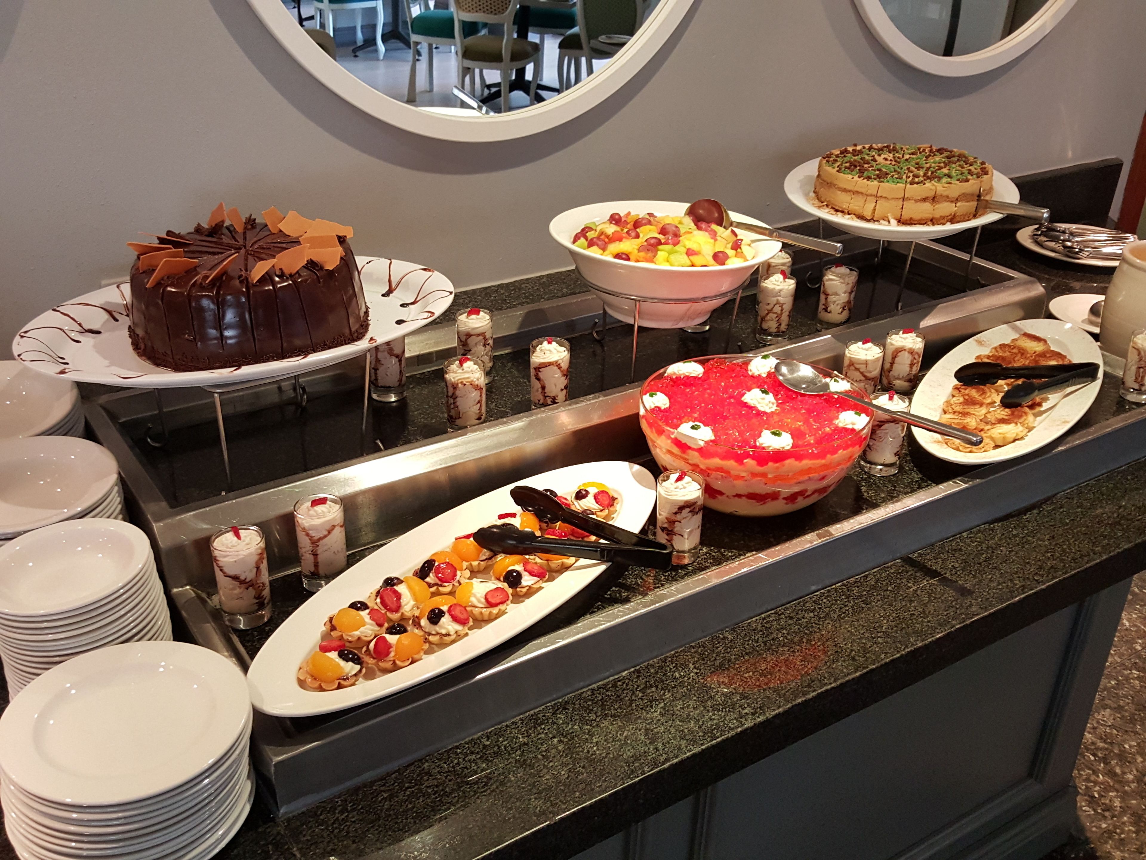 Een buffet met diverse desserts, zoals taarten, fruitgebakjes en doorlepelagen.