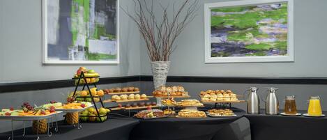 A buffet table with various food items and a decorative vase.