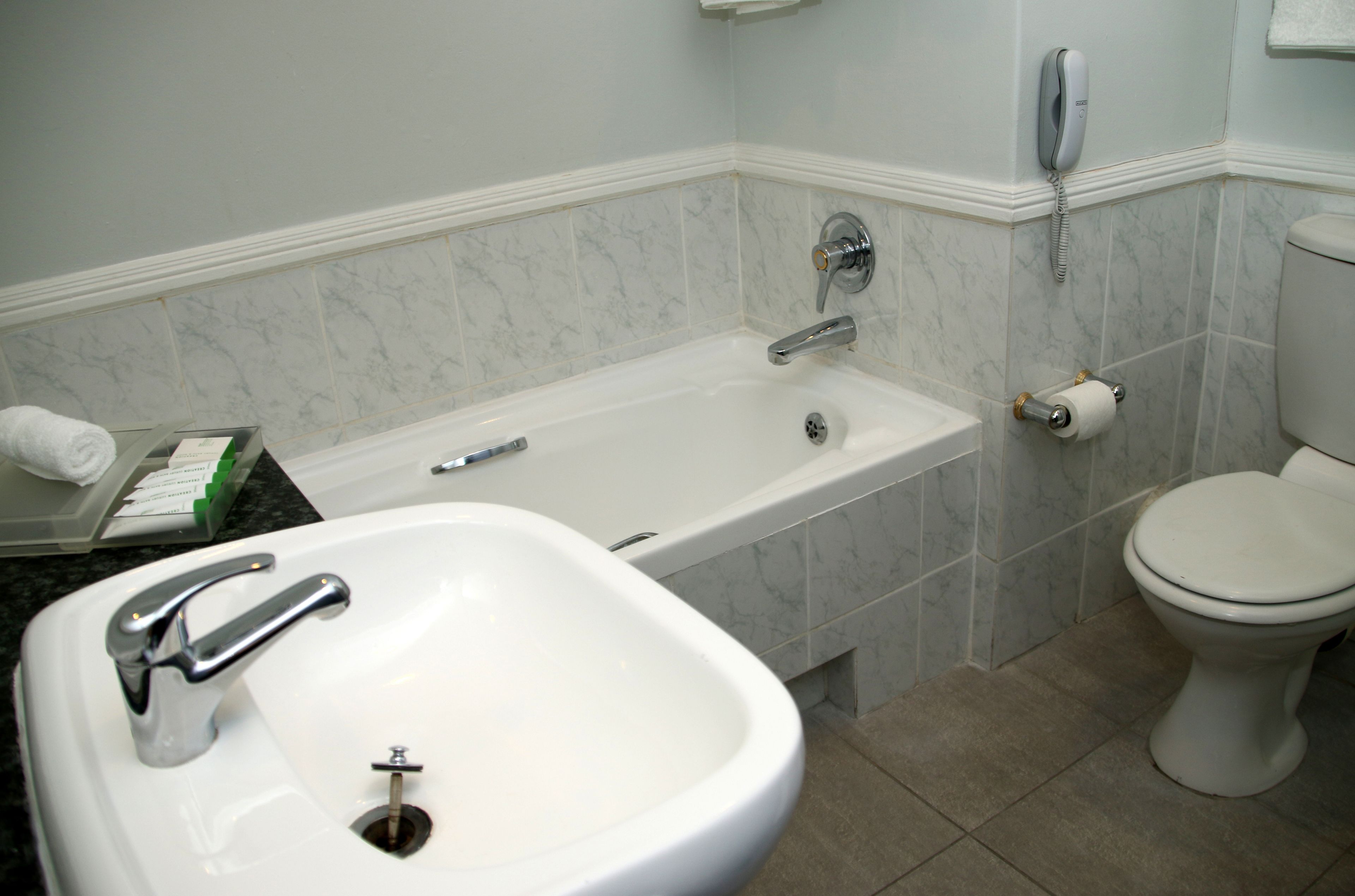 A bathroom with a white sink, a bathtub, and a toilet.