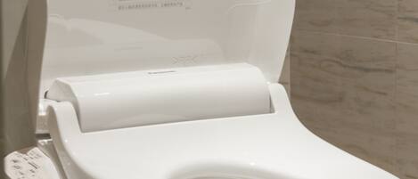A modern toilet with a control panel and a toilet paper holder.