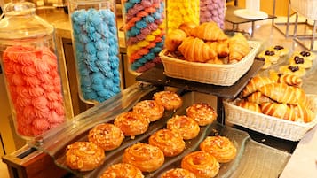 A display of pastries and desserts, including croissants and pastries with colorful frosting.