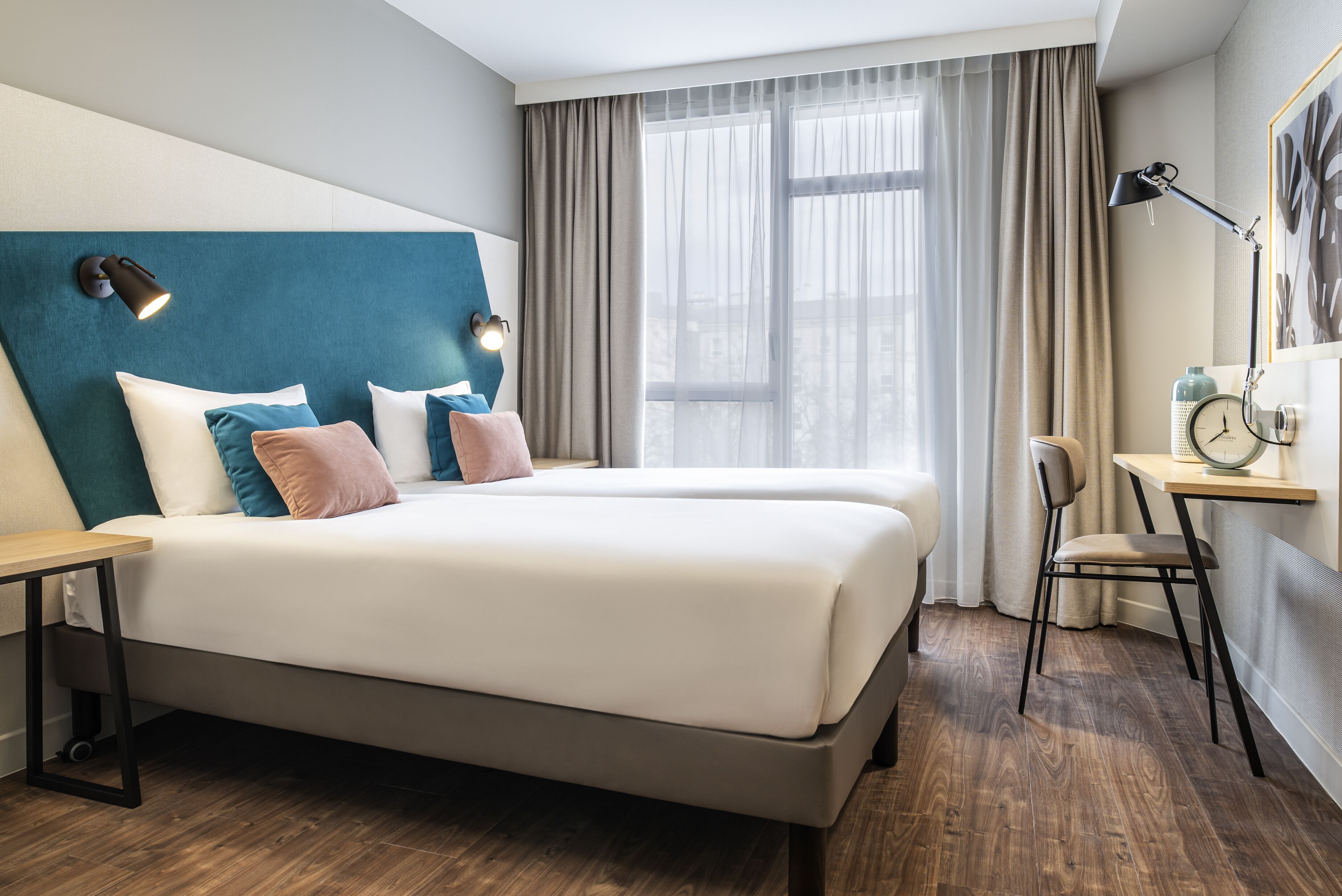Una habitación de hotel moderna con una cama grande, un escritorio y una silla.