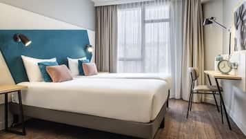 Una habitación de hotel moderna con una cama grande, un escritorio y una silla.