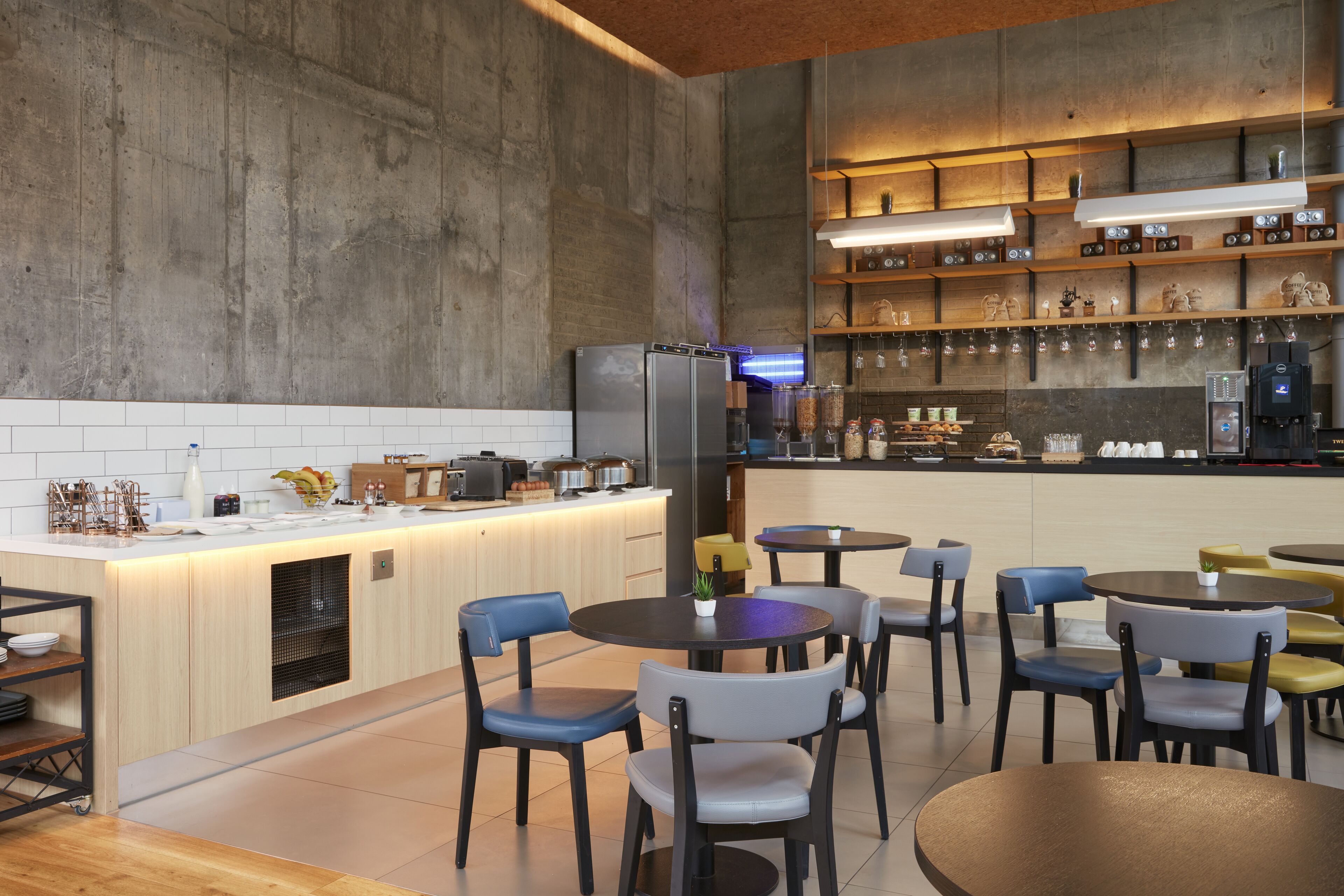 Una cuina moderna amb una illa central, zona de bar amb prestatges i places per a vuit persones.