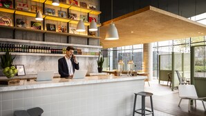 Een moderne bar met een marmeren aanrecht, flessenplanken en hangende吊り下げ灯