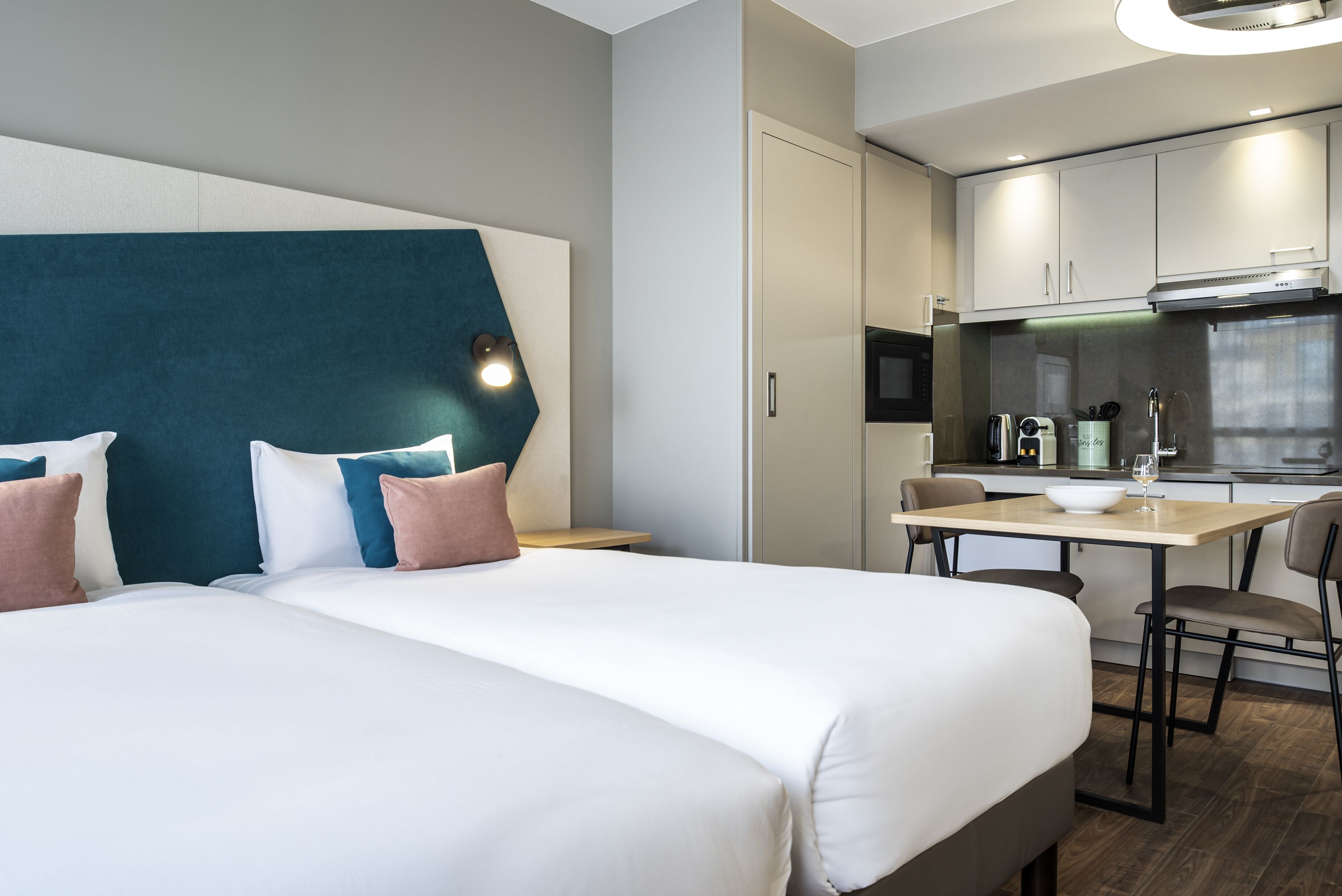 Une chambre d’hôtel avec un grand lit, un bureau et une kitchenette.