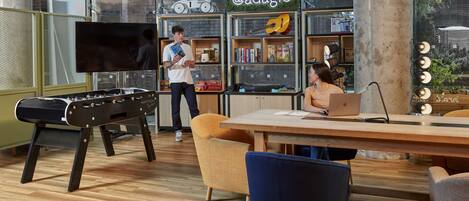 A modern indoor space with a pool table, a large TV, and a sign reading "@adagio".