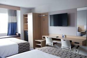 A hotel room with two beds, a desk, a chair, a TV, and a wardrobe. - Microtel Inn & Suites by Wyndham Camp Lejeune/Jacksonville (Jacksonville)