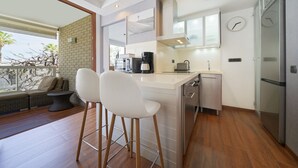 Una cocina moderna con barra, cafetera y refrigerador.