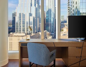 A modern office space with a large desk, a chair, and a view of a cityscape through large windows. - The Westin Austin Downtown (Austin)