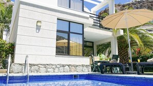 Un bâtiment moderne doté d’une piscine, d’un espace extérieur aménagé et offrant une vue sur le paysage environnant.