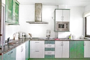 Cafetera o tetera, frigorífico grande, microondas y placa de cocina