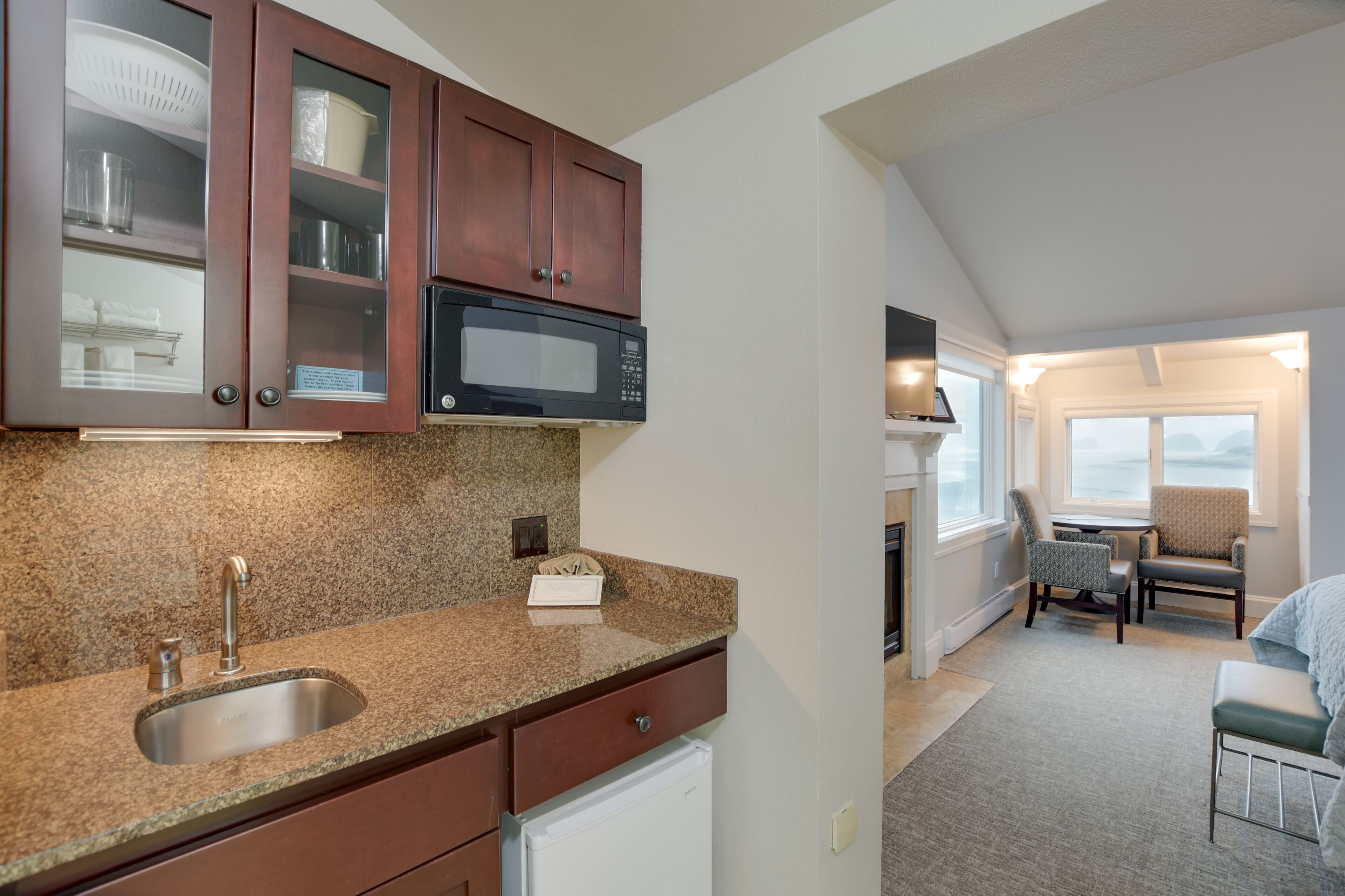 A kitchen with granite countertops, a stainless steel sink, and wooden cabinets.