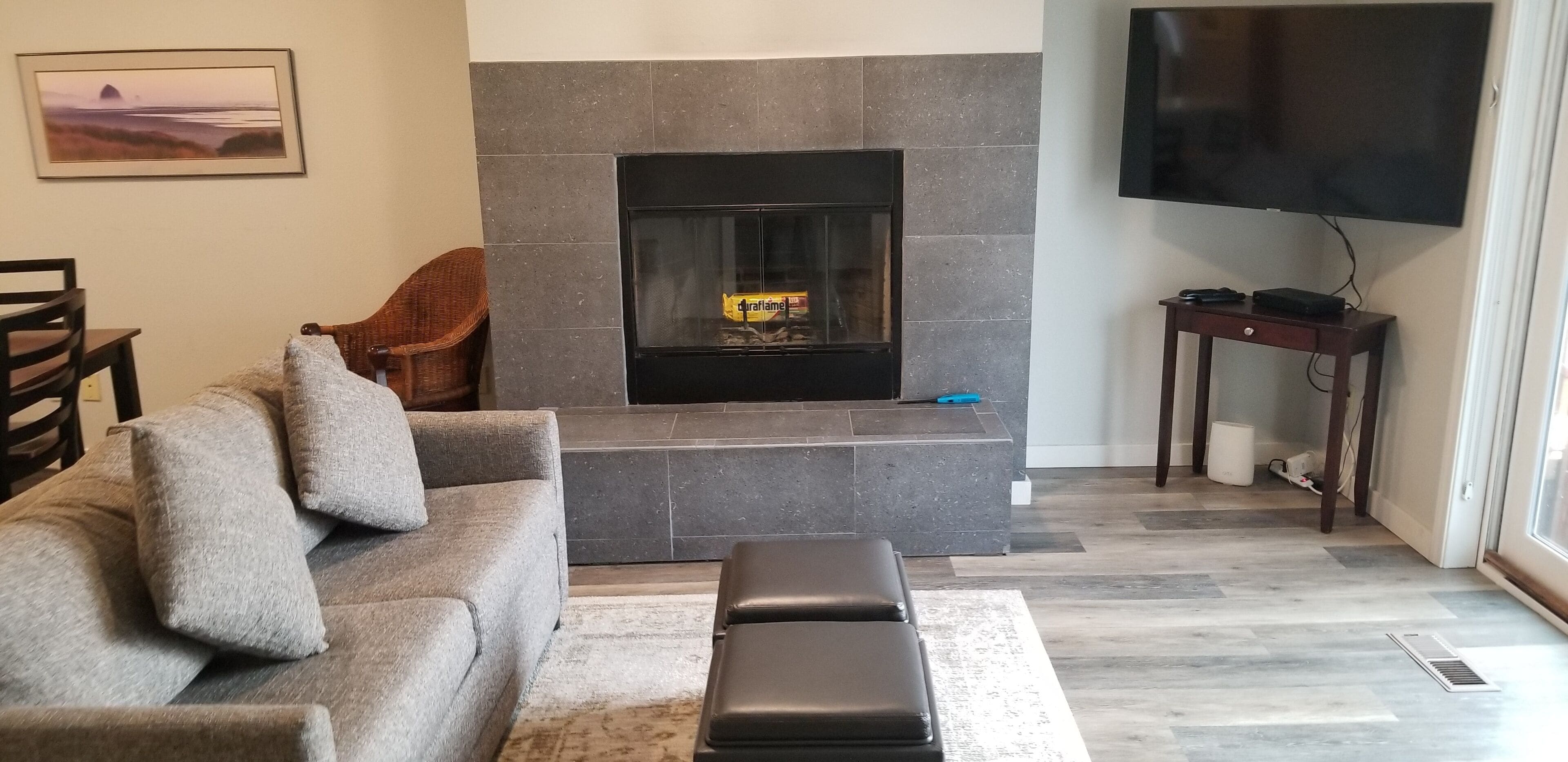 Un salon avec une cheminée, un canapé, un téléviseur et une petite table.