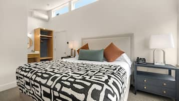 A hotel room with a large bed, a nightstand, a wardrobe, and a window with a view.