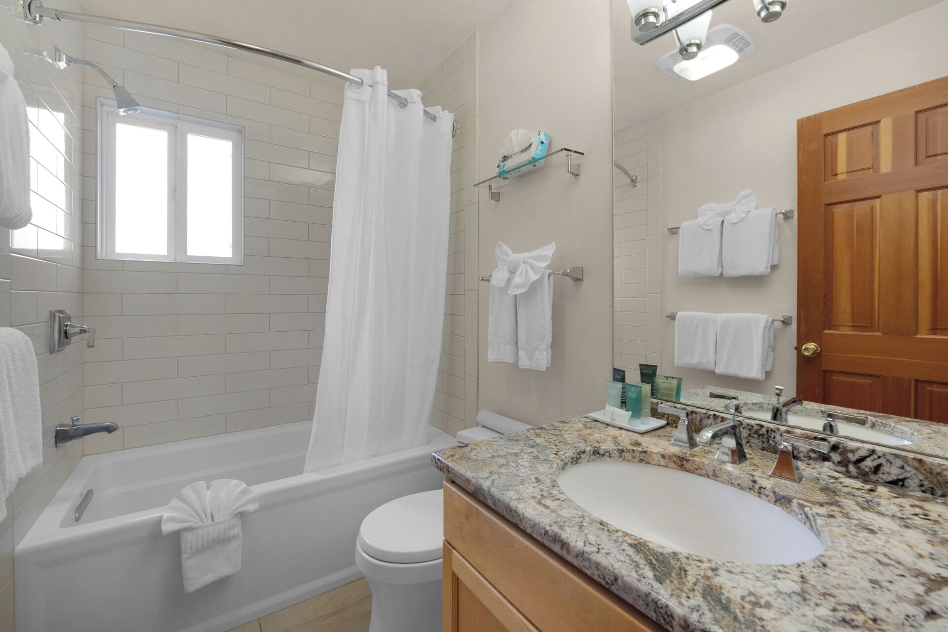 Une salle de bain moderne équipée d’une baignoire, d’une douche, de toilettes et d’un meuble-lavabo avec un évier et un miroir.